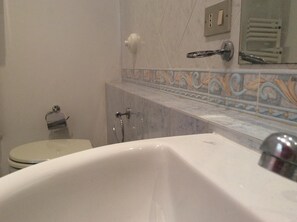 Tina con regadera, secadora de cabello, bidet, toallas 