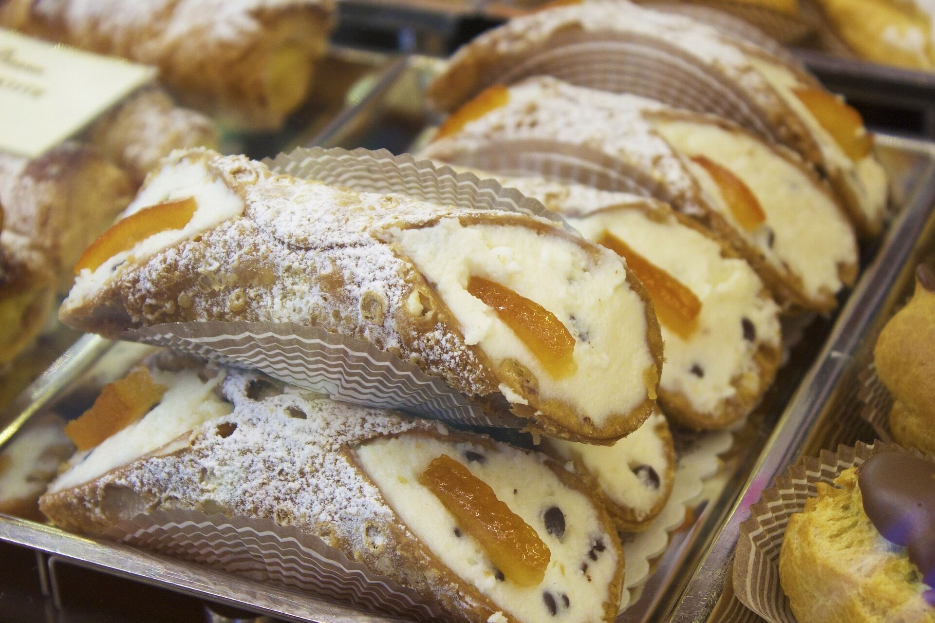 Une présentation de pâtisseries saupoudrées de sucre glace et décorées de tranches d’orange.