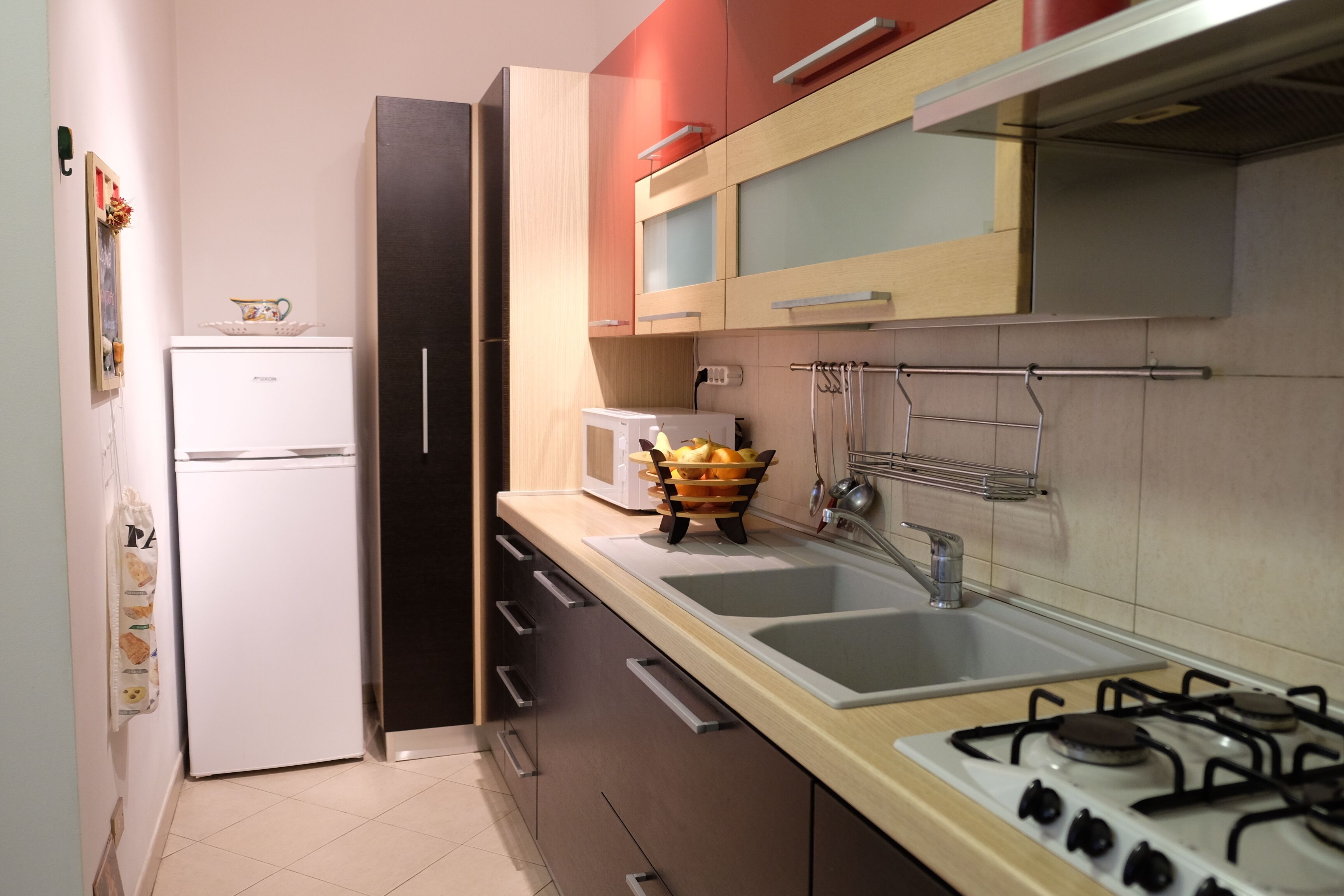 A modern kitchen with a refrigerator, stove, sink, and various appliances.