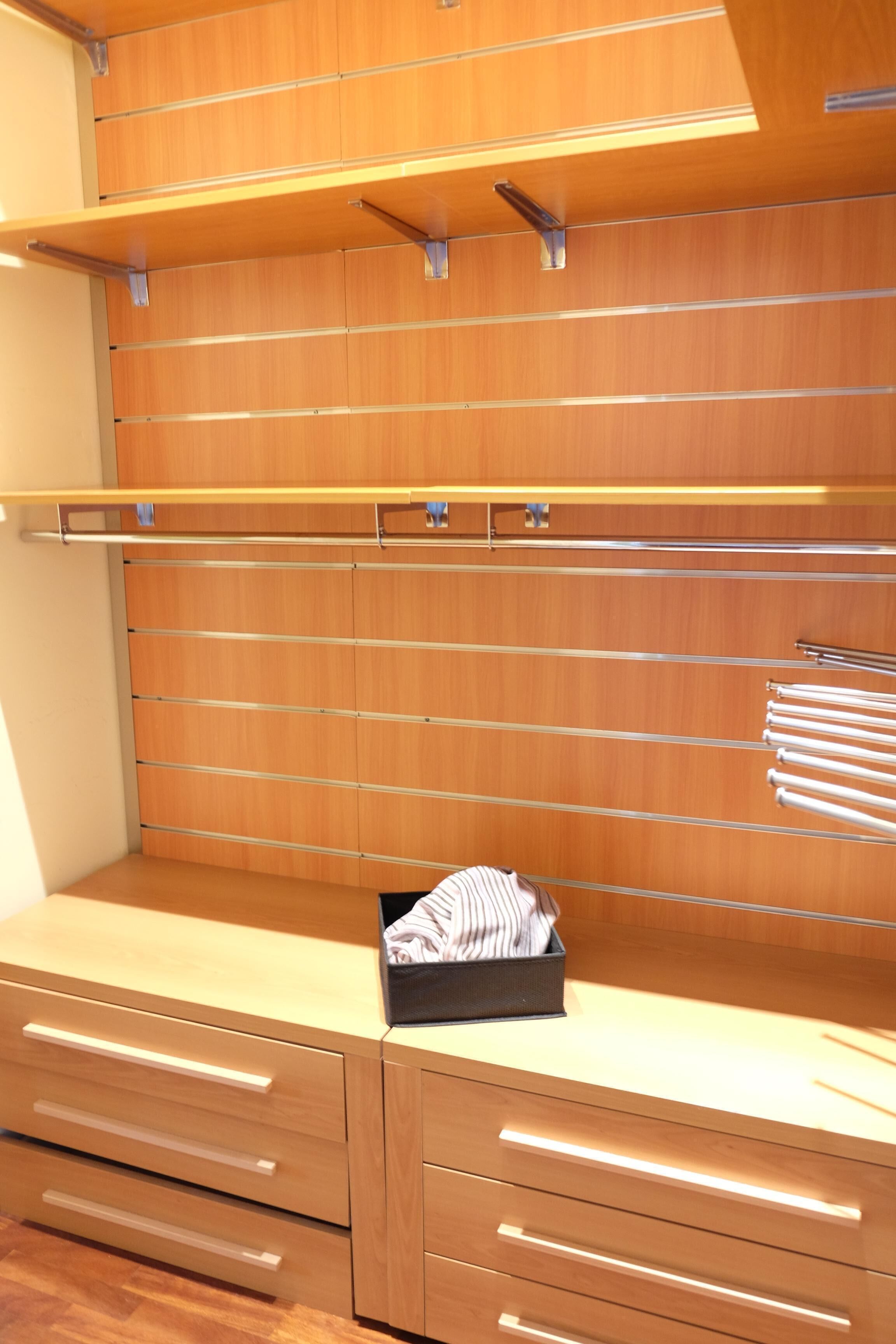 A modern, minimalist room with wooden cabinetry and built-in shelves.