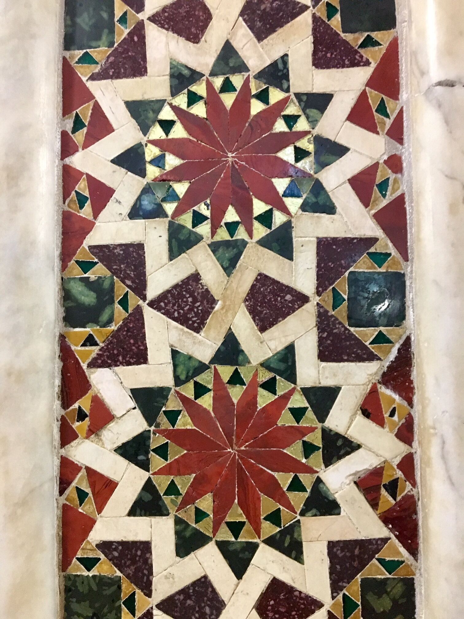 Un motif détaillé en mosaïque, composé de formes géométriques et orné d’une étoile au centre.