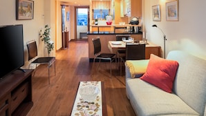 A modern living room with a TV, sofa, and dining area. - Comfortable, contemporary and tranquil flat with sea views in the centre of town (Fuengirola)