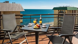 A balcony with two chairs, a table with breakfast, and a view of the ocean. - Comfortable, contemporary and tranquil flat with sea views in the centre of town (Fuengirola)
