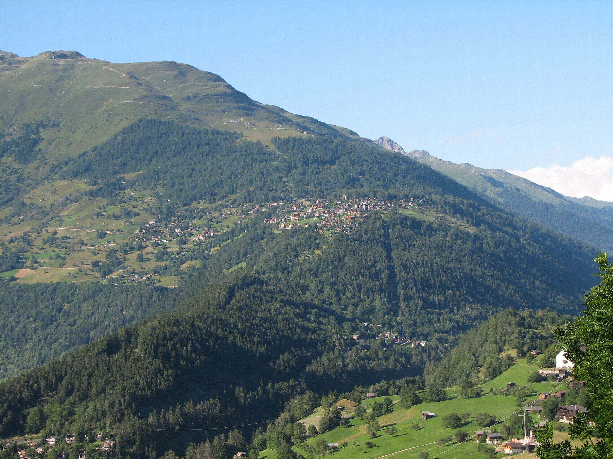 A mountainous landscape with a small village nestled among the hills.