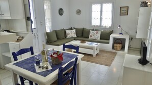 Una sala moderna con un sofá, una mesa de comedor y un televisor.