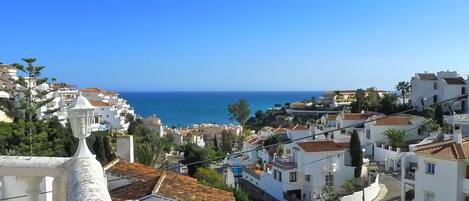 A coastal town with white buildings, a clear blue sky, and a view of the sea.