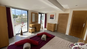 Een moderne slaapkamer met een groot bed, een kaptafel, een spiegel en een kledingkast.