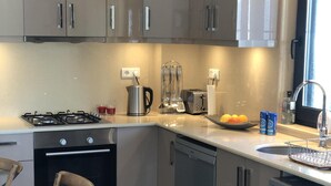 Een moderne keuken met roestvrijstalen apparatuur, een eetgedeelte met houten stoelen en een vaas tulpen.