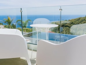 Relax on the spacious outdoor terrace with a stunning ocean view and lush surroundings, perfect for dining or unwinding.