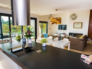 Enjoy a home away from home with a sleek kitchen, dining area, and cozy living space featuring a fireplace and flat-screen TV.