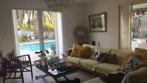 Sala de estar com sofá, mesa de centro e um cão.