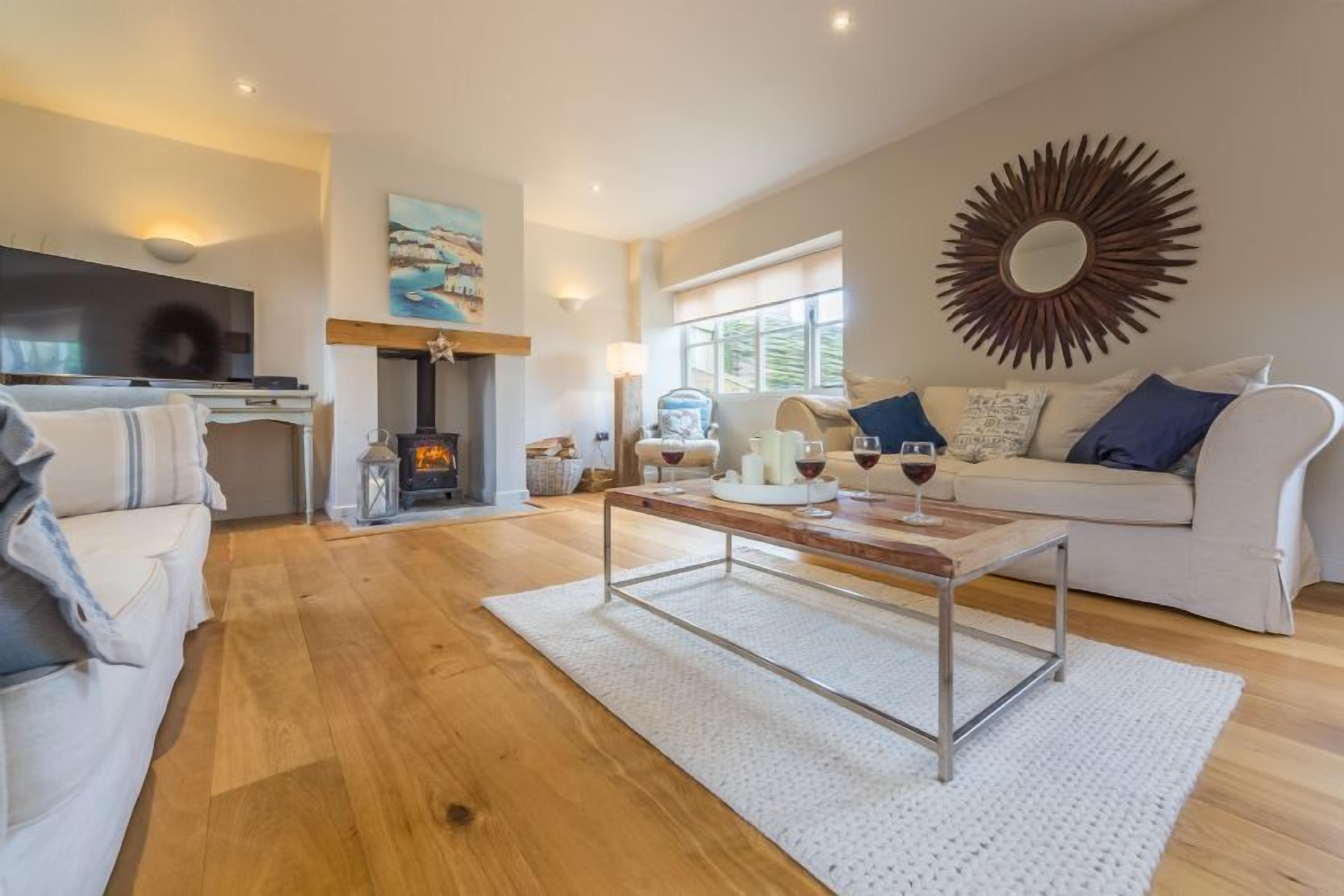 A modern living room with a fireplace, a sofa, a coffee table, and a TV.