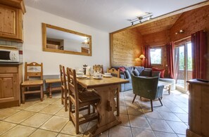 Un interno in legno con un tavolo da pranzo, sedie, un divano e una televisione.