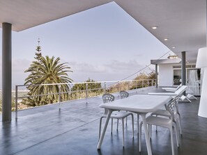 A modern outdoor patio with a white table and chairs, a view of palm trees, and a clear sky. - Your "Boutique" Home with views!! (La Orotava)