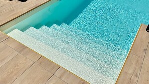 A swimming pool with clear water, surrounded by wooden deck flooring. - Residence Toli Pool with outdoor heated Pool 30° (Ledro)