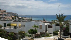 A coastal residential area with white buildings, a clear blue sky, and a view of the sea. - Modern1 bed apt. full seaview. Beside Golden Mile (Los cristianos)