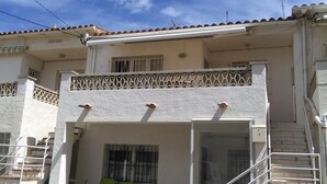 Ein zweistöckiges Gebäude mit Balkon, Treppe und einem verschlossenen Eingang.