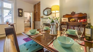 A dining area with a wooden table set for four, including green bowls and wine glasses. - Station House, Helhoughton, Norfolk (Helhoughton)