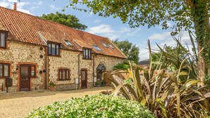A stone building with a tiled roof and multiple windows. - Hideaway Barn, Thornham, Norfolk (Thornham)
