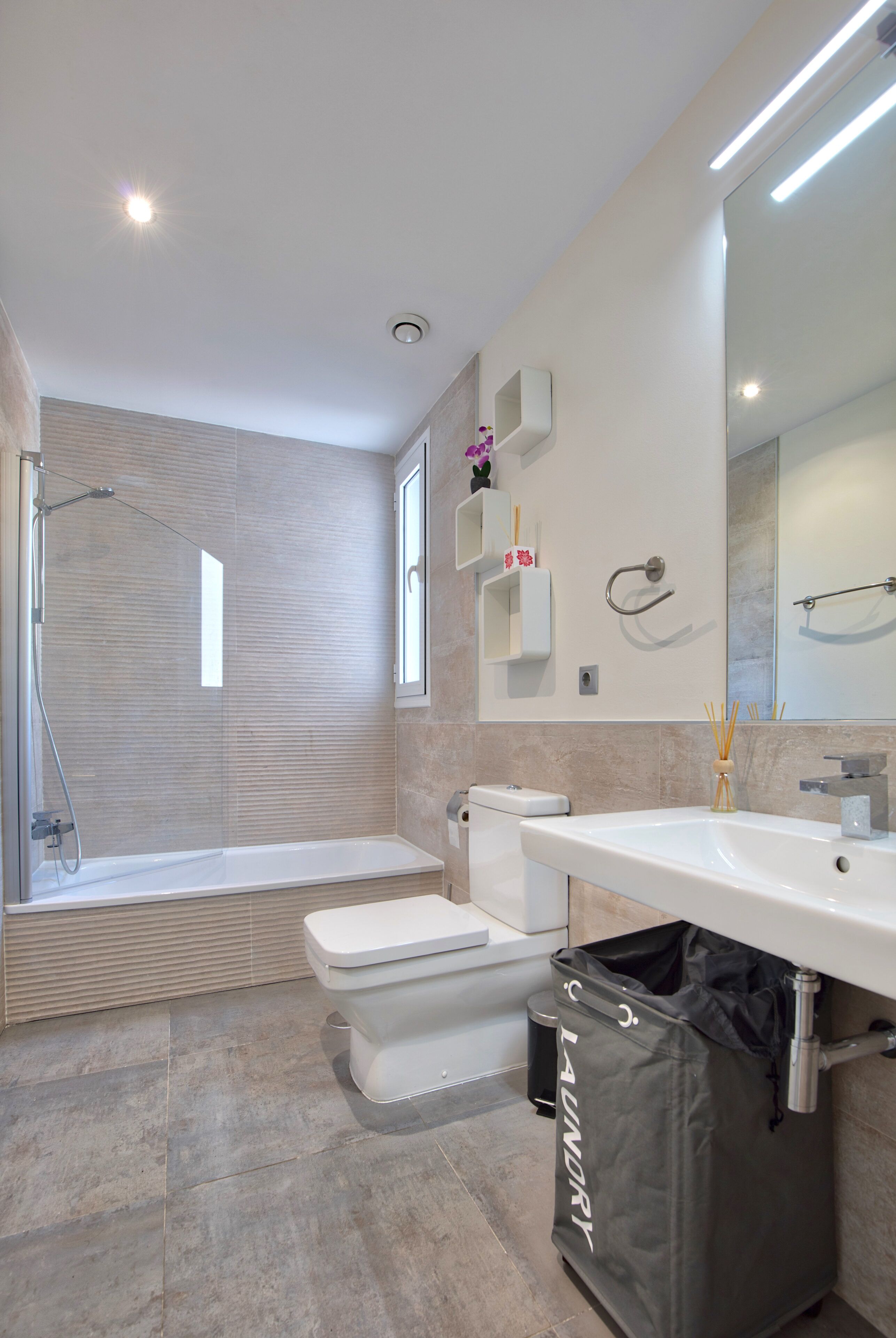Une salle de bain moderne équipée d’une douche, de toilettes et d’un lavabo.