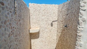 A stone-walled outdoor shower area with a built-in seat and a handheld showerhead. - Villa with parking and veranda, 900 m from the beach - San Teodoro (San Teodoro)