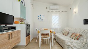 A compact living space with a kitchenette, a dining area, and a sofa. - Villa with parking and veranda, 900 m from the beach - San Teodoro (San Teodoro)