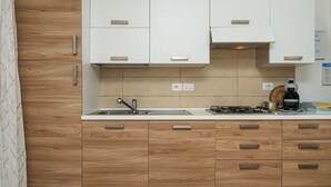 A modern kitchen with wooden cabinetry, a stainless steel sink, and a gas stove. - Villa with parking and veranda, 900 m from the beach - San Teodoro (San Teodoro)