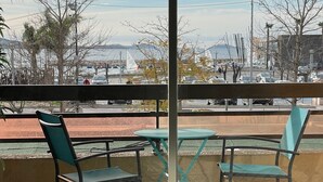 A balcony with a bed, two chairs, and a table. - Hyper city center with sea-view terrace, right on the beach. (Bandol)