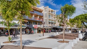 A pedestrian area with shops, trees, and a modern building. - Hyper city center with sea-view terrace, right on the beach. (Bandol)