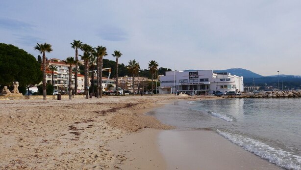 A beach with a yacht club and buildings in the background. - Hyper city center with sea-view terrace, right on the beach. (Bandol)