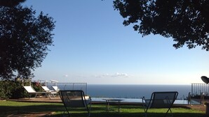 A view of the ocean from a grassy area with two lounge chairs facing the water. - LE QUERCE - Villa with spectacular sea view and swimming pool (Maratea)