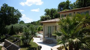 Une villa dotée d’un patio, d’une petite piscine et d’une végétation luxuriante.