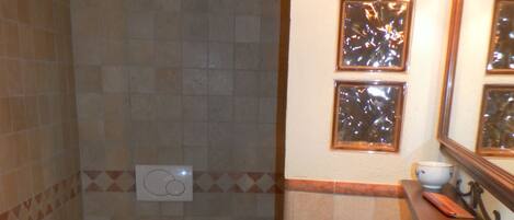 A bathroom with a toilet, sink, and mirror.