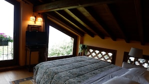 Une chambre à coucher avec un lit, une télévision, une fenêtre et une lampe.