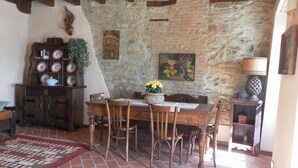 A rustic dining area with a stone wall, wooden furniture, and a tiled floor. - A piece of paradise nearby Milan and Como Lake (Montevecchia)