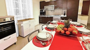 A modern kitchen with dark cabinets, a microwave, and an oven. A dining table is set with plates, glasses, and a fruit platter. - Close to centre of Lucca. Perfect base for exploring. Exclusive use of pool, A/c (Lucca)