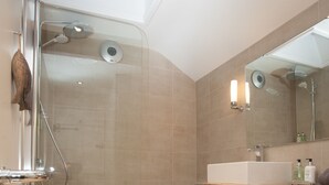 A modern bathroom with a glass-enclosed shower, a wooden vanity, and a large mirror. - Charming Cottage in Prime Position with Castle Views, 12 The Wynding (Bamburgh)