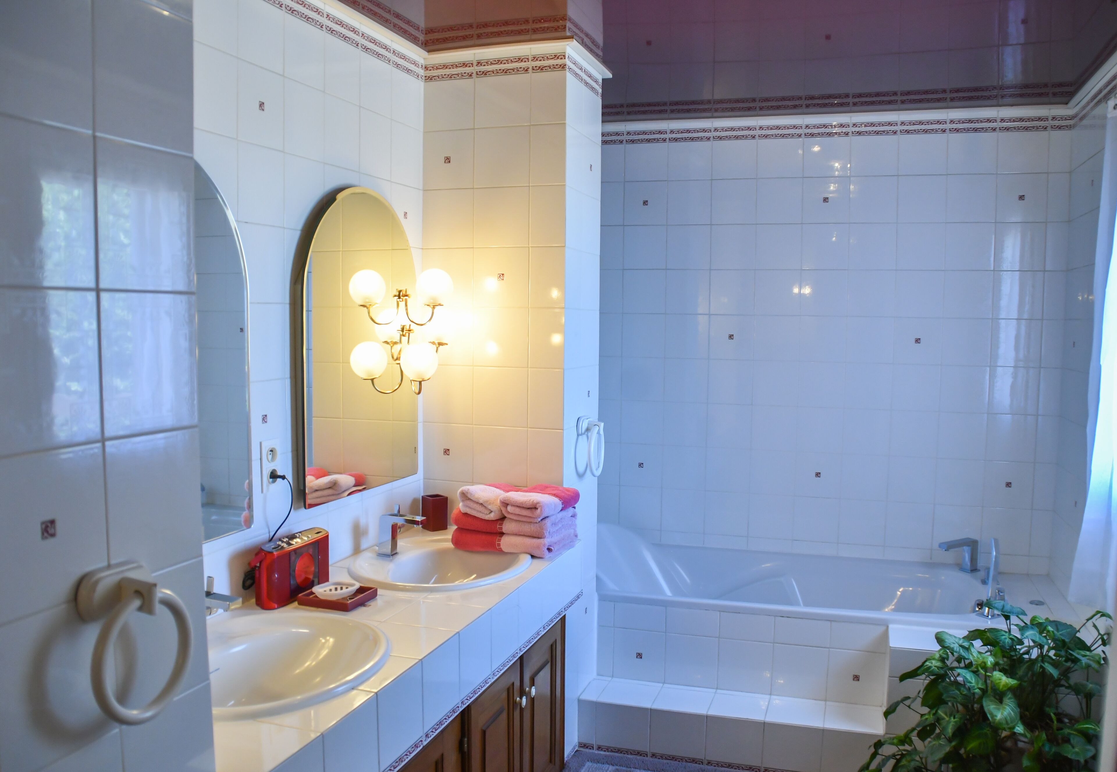 A bathroom with a sink, mirror, and bathtub.