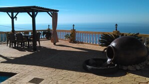 An outdoor terrace with a table and chairs, a pergola, and a view of the sea. - VILLA WITH SEA AND MOUNTAIN VIEWS, NEAREST BEACH 6KM (Almuñecar)