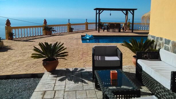 A terrace with a pool, outdoor furniture, and a view of the sea. - VILLA WITH SEA AND MOUNTAIN VIEWS, NEAREST BEACH 6KM (Almuñecar)