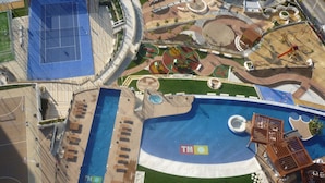 An aerial view of a resort with a large swimming pool, sun loungers, and a tennis court. - APARTMENT WITH FANTASTIC VIEWS TO THE BEACH TO THE SEA AND TO THE RESIDENTIAL COMPLEX (Benidorm)