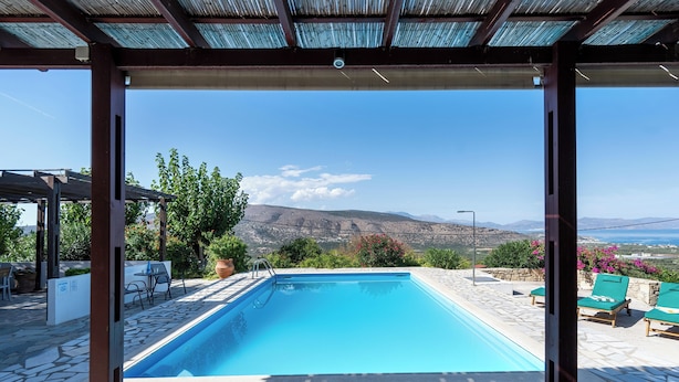 A swimming pool with a view of mountains and the sea.