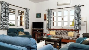 A living room with a sofa, a television, and a coffee table.