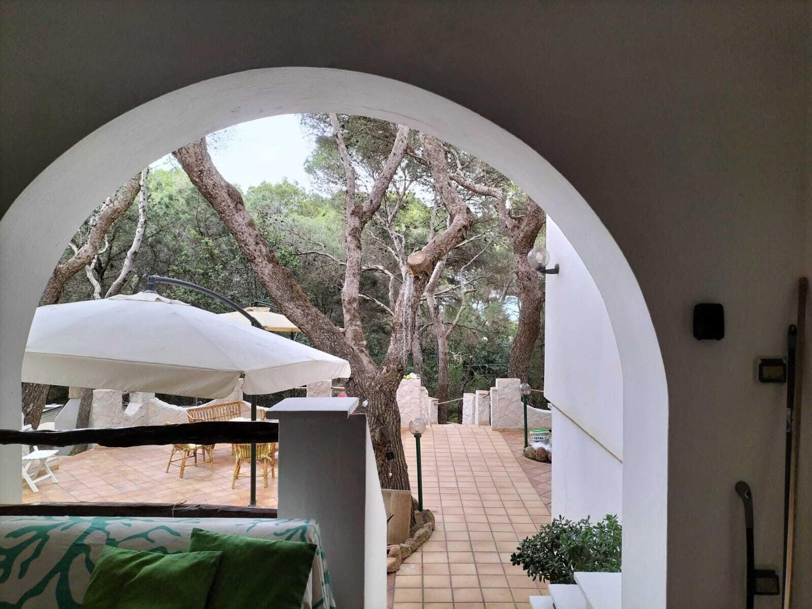 An outdoor seating area with white umbrellas, a stone table, and chairs.
