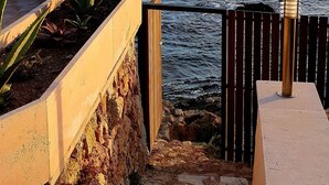 A stone staircase leading to a terrace overlooking a body of water with mountains in the distance. - Superb villa "feet in the water"  (Roquebrune-Sur-Argens)