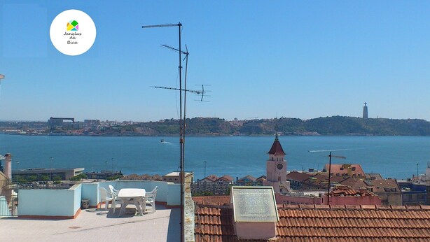 Paesaggio costiero con vista limpida sul mare, una torre campanaria in evidenza e un logo nell'angolo in alto a sinistra.