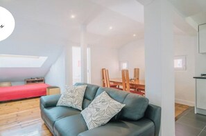 Un appartement moderne avec une chambre en mezzanine, un coin repas et une kitchenette.