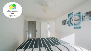 Una camera da letto con un letto, una porta e tre quadri astratti appesi al muro.
