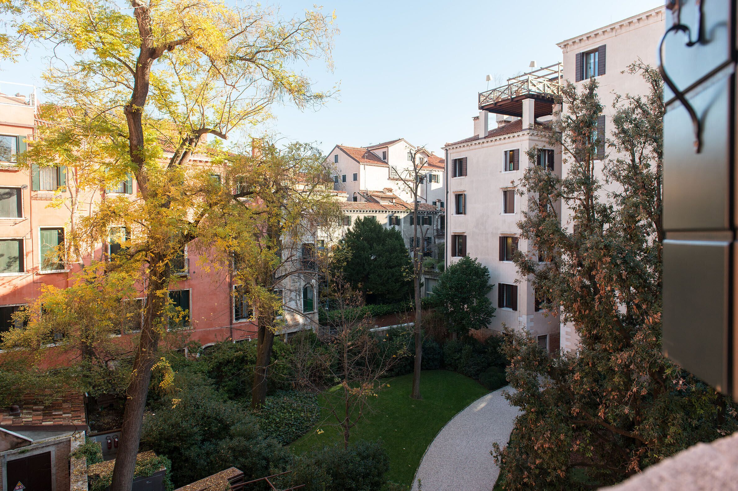 A courtyard with buildings, trees, and a pathway.