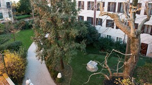 Un cortile con un vialetto, una panchina in pietra e un albero.
